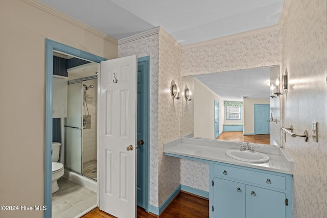 bathroom featuring a shower with shower door, wood-type flooring, crown molding, and vanity