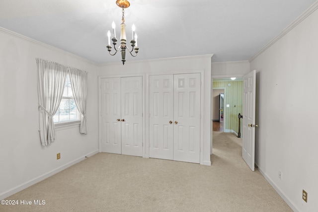 unfurnished bedroom with light carpet, an inviting chandelier, multiple closets, and ornamental molding