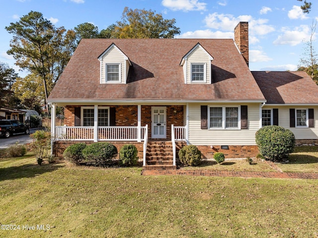 new england style home with covered porch and a front yard