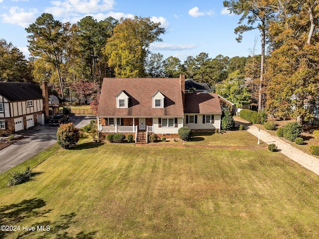 view of front of house with covered porch, a front yard, and a garage