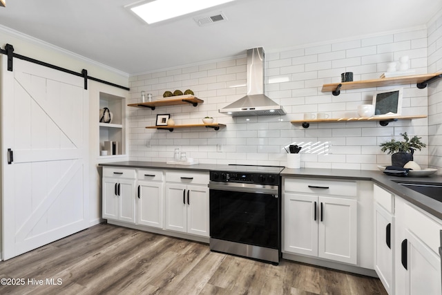 kitchen featuring white cabinetry, electric range, ventilation hood, ornamental molding, and a barn door