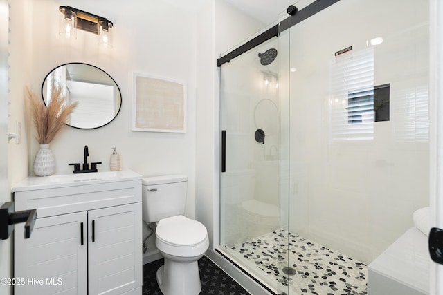 bathroom featuring an enclosed shower, vanity, and toilet