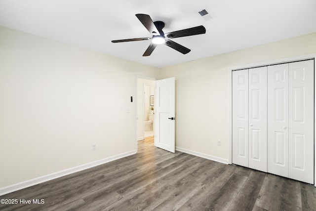 unfurnished bedroom with a closet, dark hardwood / wood-style floors, and ceiling fan