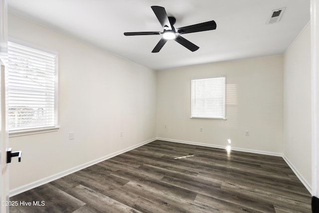 empty room with ceiling fan and dark hardwood / wood-style flooring