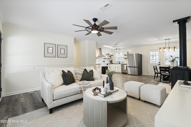 living room with crown molding, sink, ceiling fan, and light hardwood / wood-style flooring