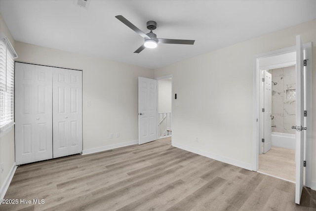 unfurnished bedroom with light wood-type flooring, connected bathroom, ceiling fan, and a closet