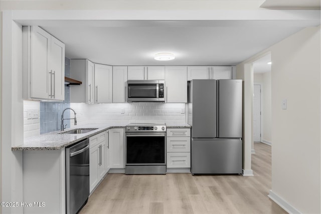 kitchen featuring sink, stainless steel appliances, light stone countertops, white cabinets, and decorative backsplash