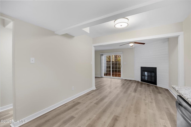 unfurnished living room with beamed ceiling, ceiling fan, a fireplace, and light wood-type flooring