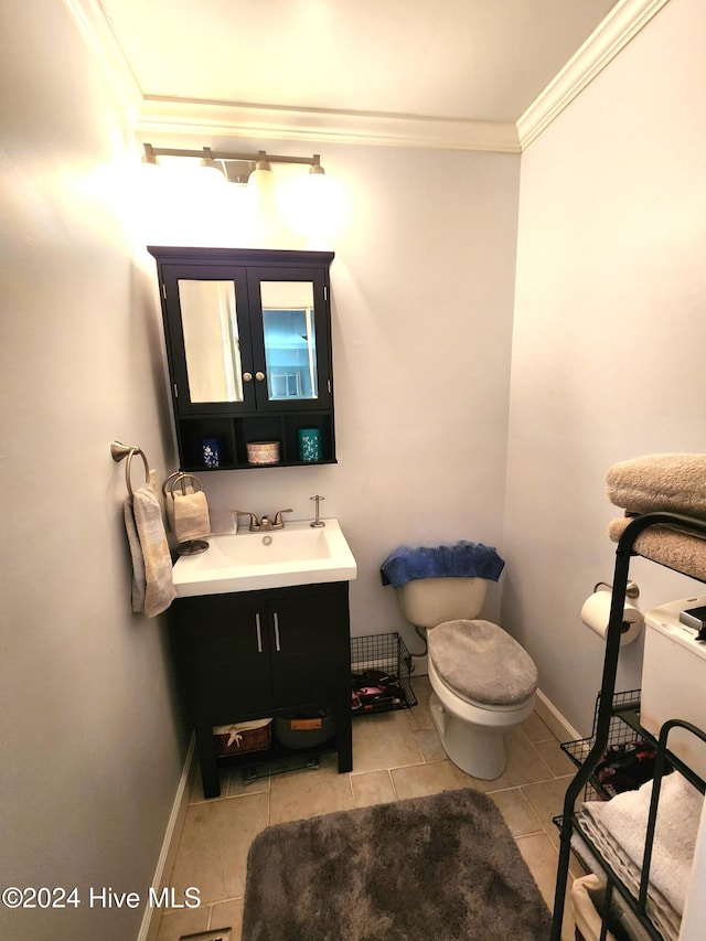 bathroom featuring tile patterned flooring, vanity, toilet, and ornamental molding