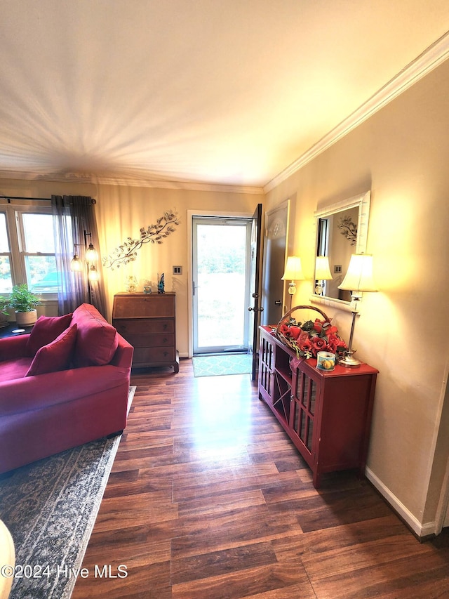 living area with plenty of natural light, baseboards, wood finished floors, and crown molding