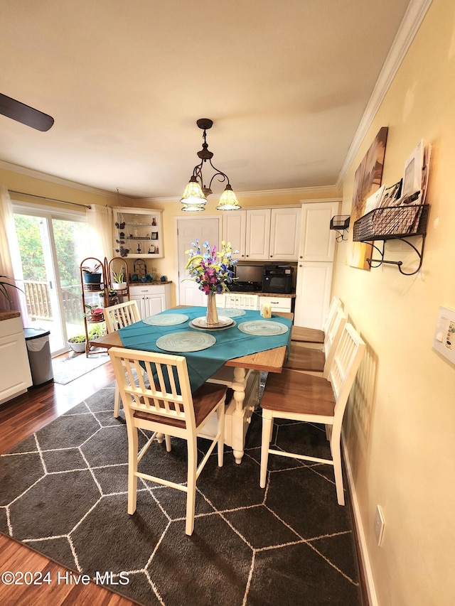 dining space with dark hardwood / wood-style flooring and crown molding