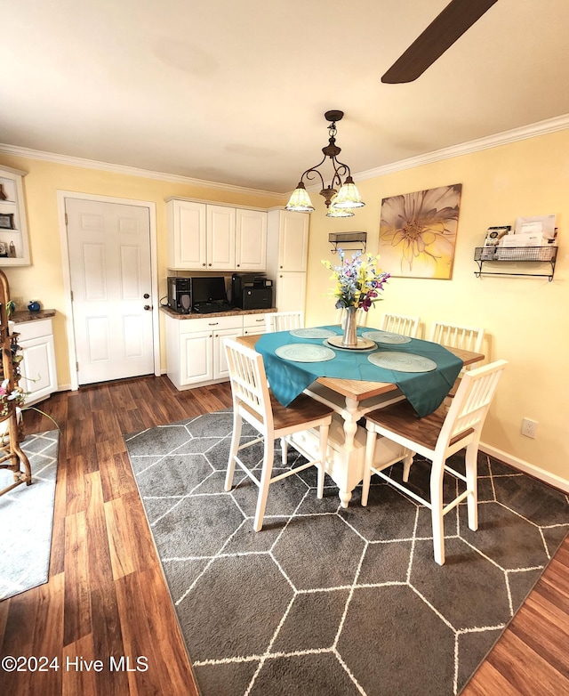 dining room featuring a ceiling fan, ornamental molding, and dark wood finished floors