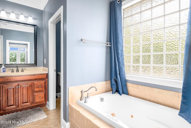 bathroom with tile patterned flooring, vanity, crown molding, and tiled bath