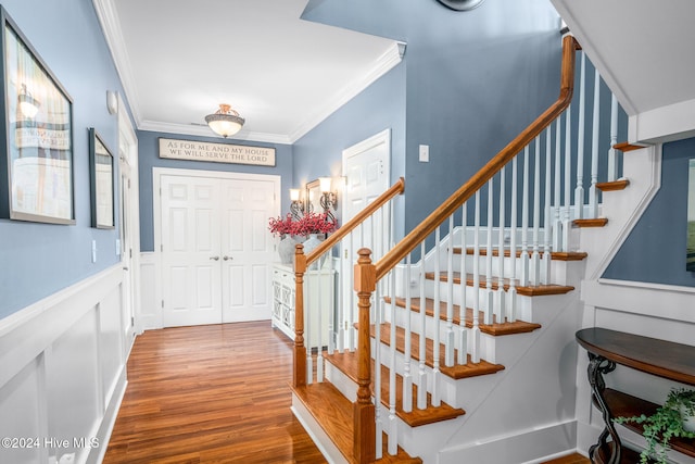 entrance foyer with ornamental molding and hardwood / wood-style flooring