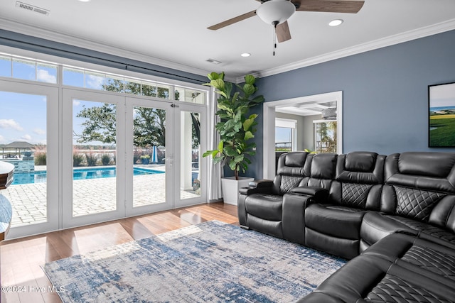 living room with crown molding, light hardwood / wood-style flooring, and ceiling fan