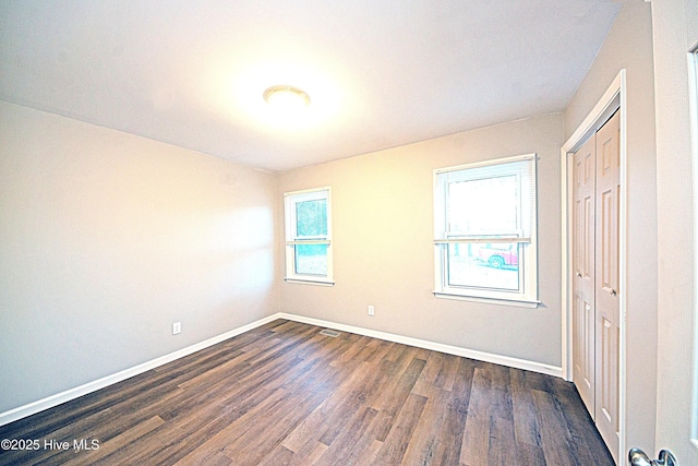 unfurnished room featuring dark wood-type flooring