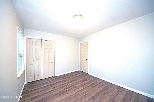 unfurnished bedroom featuring dark wood-type flooring and a closet