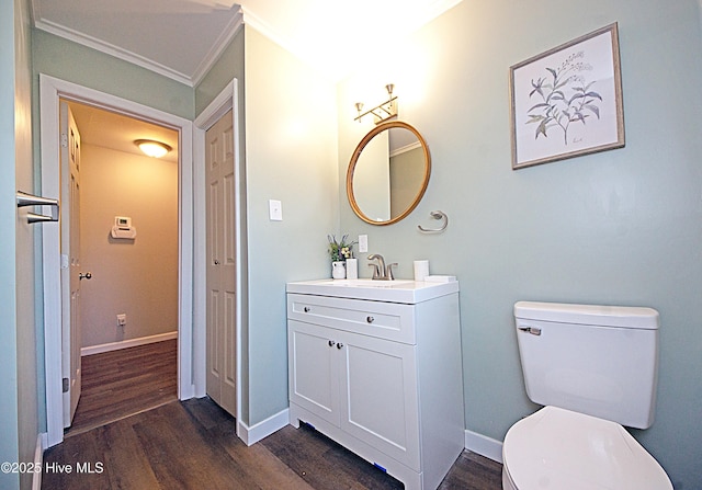 bathroom with vanity, ornamental molding, hardwood / wood-style floors, and toilet