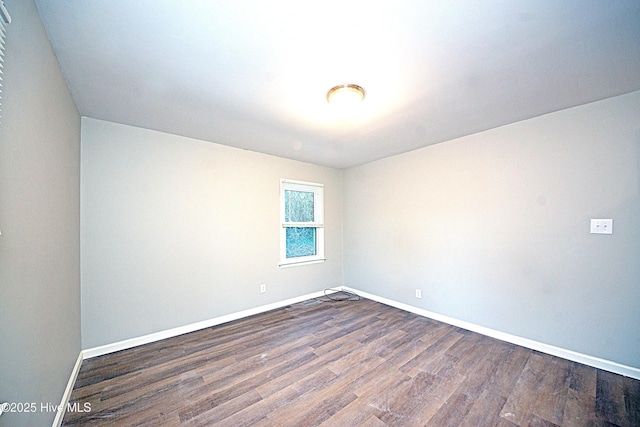 spare room with dark wood-type flooring