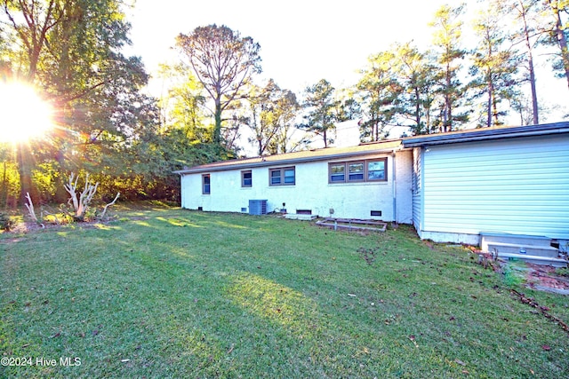 rear view of property with a yard and central AC