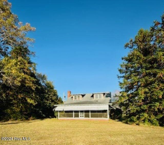 rear view of property featuring a yard