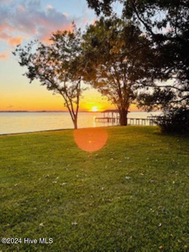 yard at dusk featuring a water view