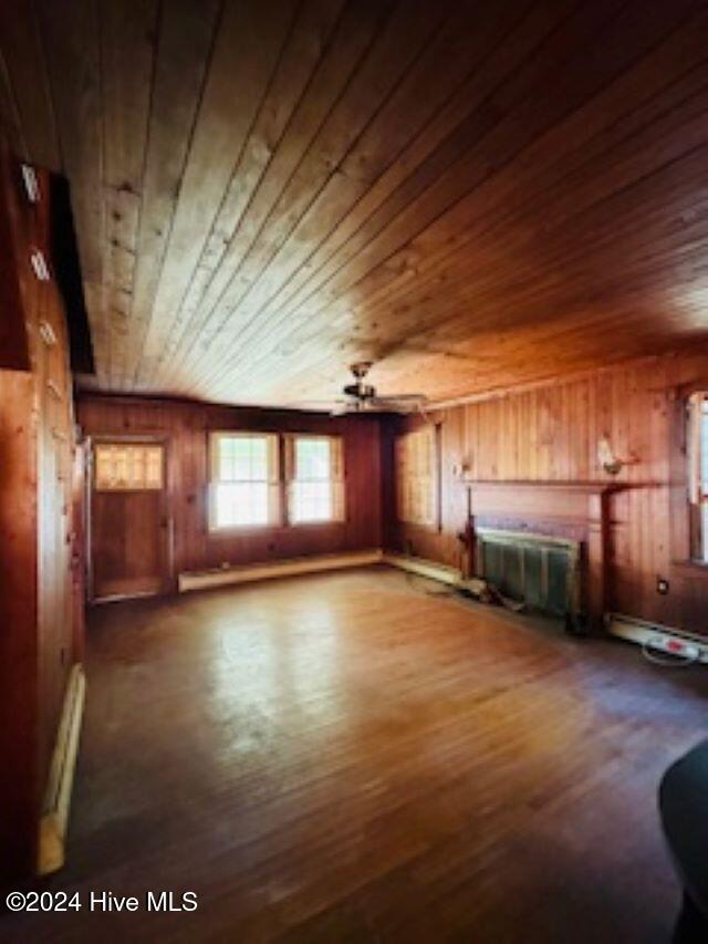 interior space featuring ceiling fan, wooden ceiling, a baseboard heating unit, and hardwood / wood-style flooring