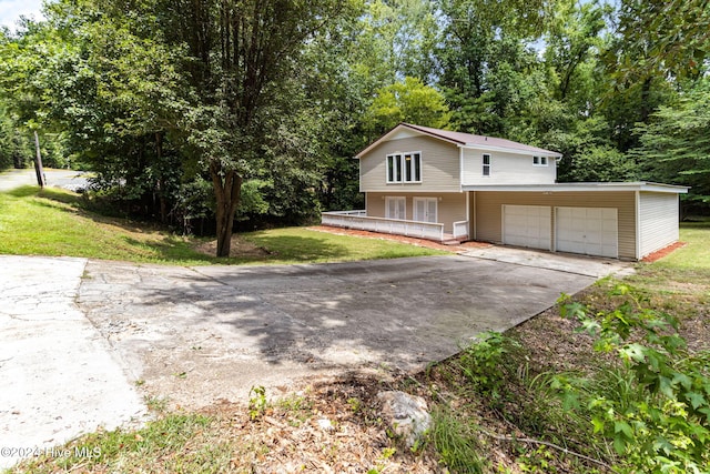 front of property featuring a porch, a garage, and a front lawn