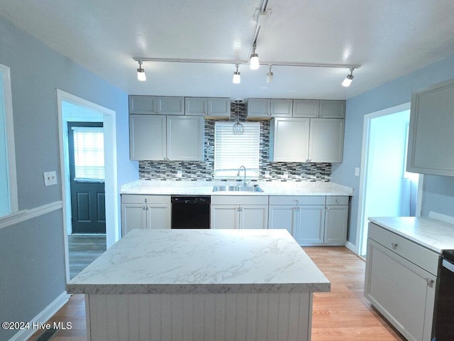 kitchen featuring gray cabinets, a center island, black dishwasher, and tasteful backsplash