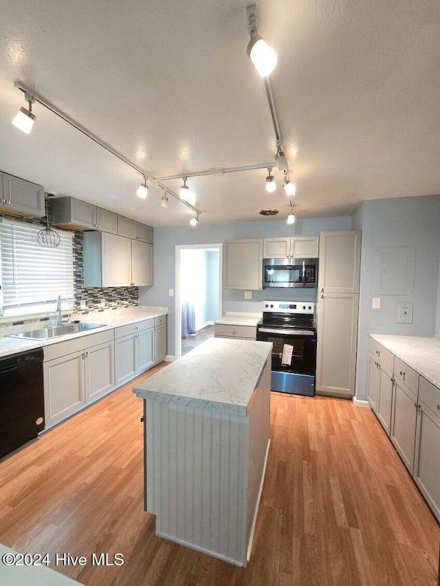 kitchen featuring a center island, stainless steel appliances, gray cabinets, and sink