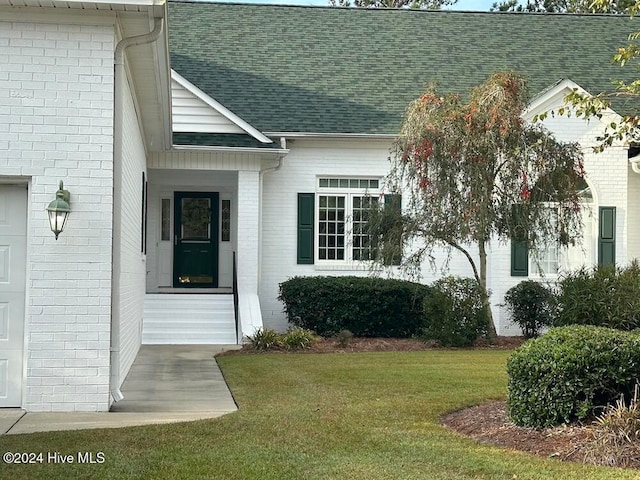 doorway to property featuring a lawn