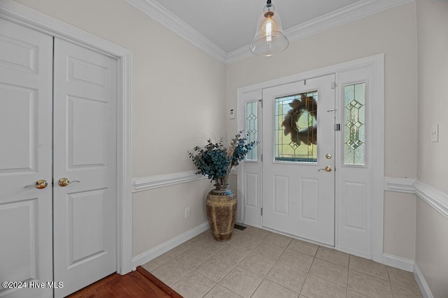 tiled foyer entrance featuring crown molding