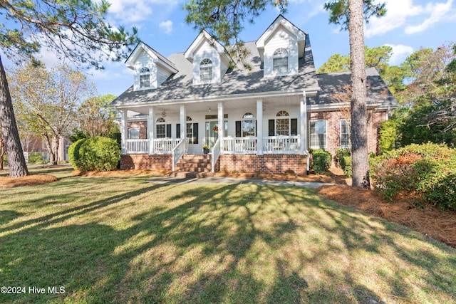 cape cod home featuring a porch and a front yard