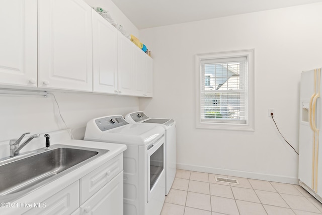 laundry room featuring cabinets, sink, light tile patterned floors, and washer and dryer