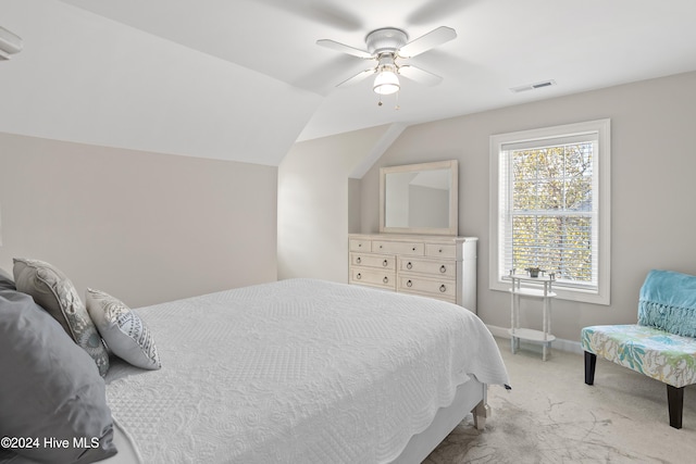 carpeted bedroom with ceiling fan and vaulted ceiling