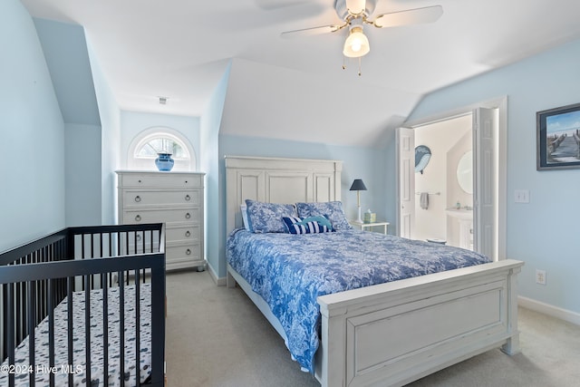 carpeted bedroom with ensuite bathroom, vaulted ceiling, and ceiling fan