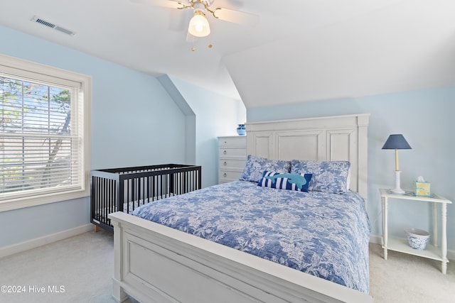 bedroom featuring ceiling fan, light carpet, and vaulted ceiling