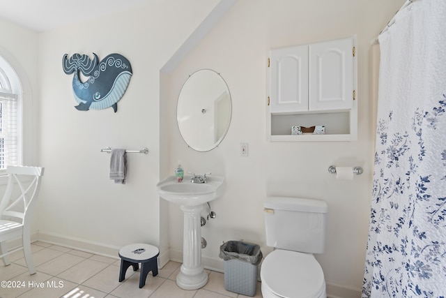 bathroom featuring a shower with curtain, tile patterned flooring, and toilet