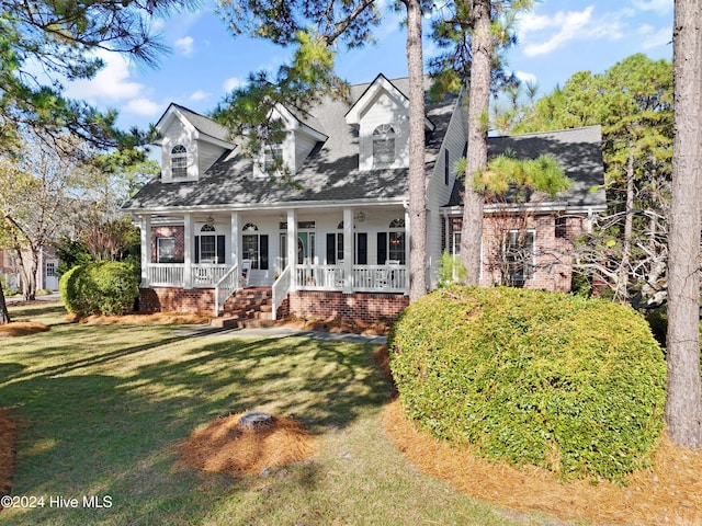 new england style home with a front yard and a porch