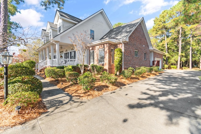 view of side of property with a porch and a garage