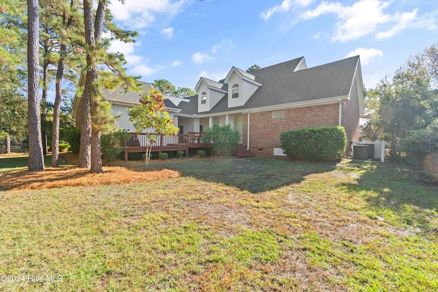 exterior space with cooling unit, a deck, and a front lawn