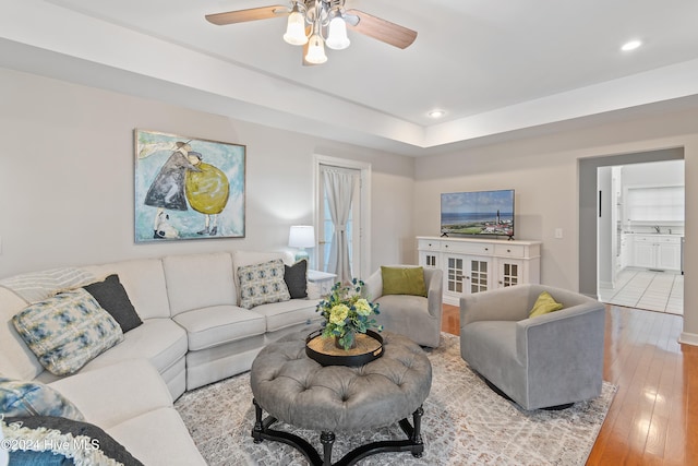 living room featuring ceiling fan, light hardwood / wood-style floors, and sink