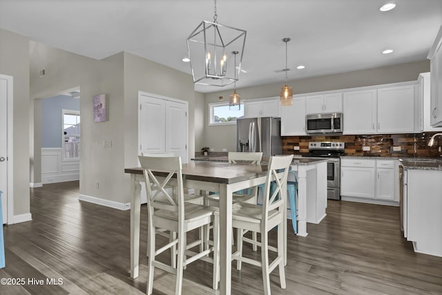 kitchen featuring white cabinets, appliances with stainless steel finishes, a kitchen island, and a healthy amount of sunlight