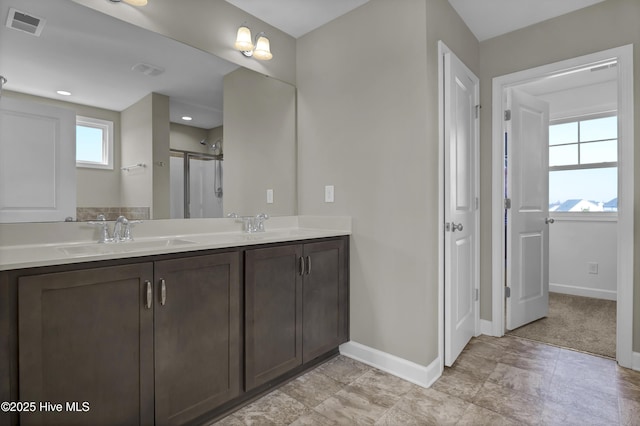 bathroom featuring a shower with door and vanity