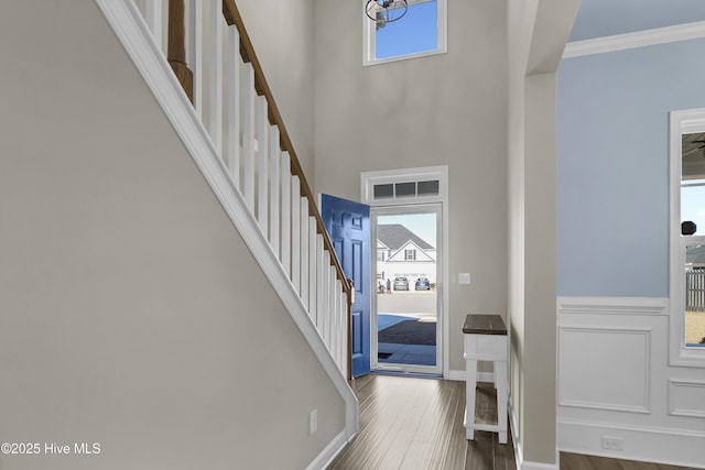 foyer featuring ornamental molding, a notable chandelier, and hardwood / wood-style flooring