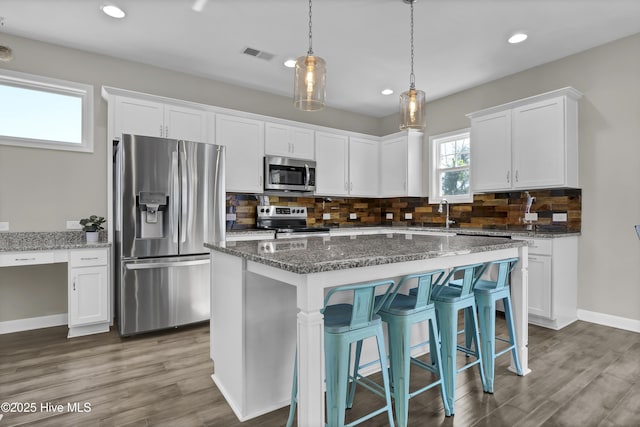 kitchen featuring white cabinets, stainless steel appliances, and stone counters