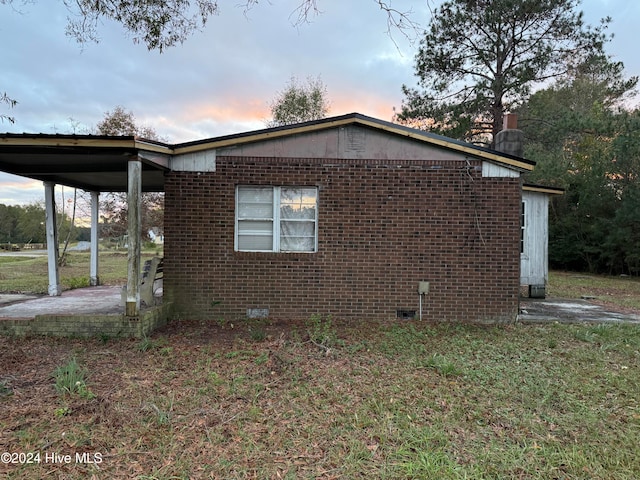 property exterior at dusk with a yard