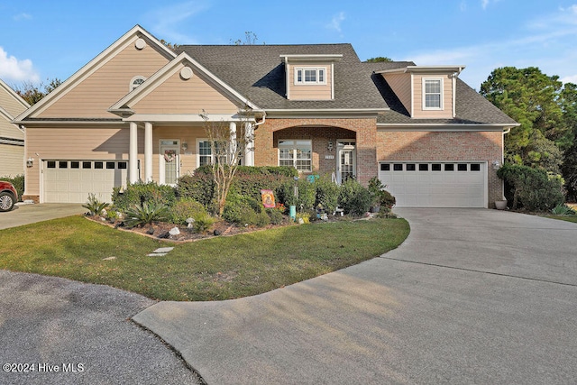 view of front of house with covered porch, a garage, and a front lawn