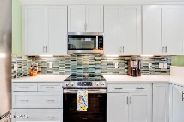 kitchen featuring decorative backsplash, white cabinetry, and appliances with stainless steel finishes