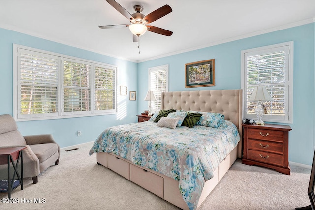 carpeted bedroom featuring ceiling fan, crown molding, and multiple windows